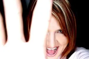 Woman smiling holding hand in front of face