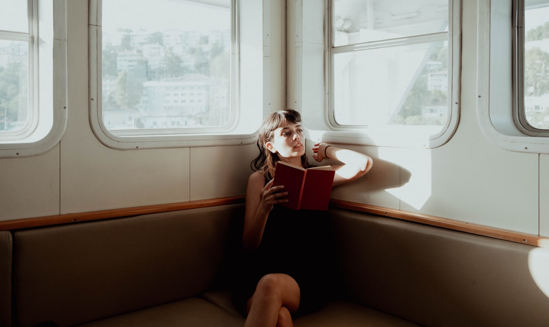 A woman sitting on a bench reading a book