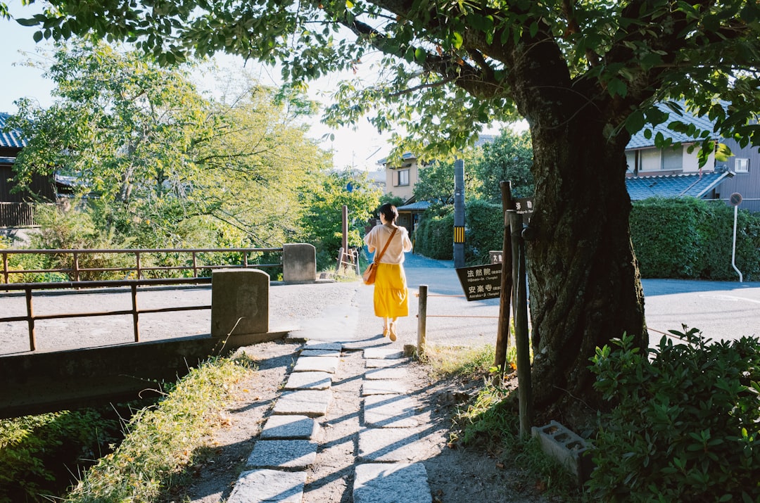 Woman walking on stone path near canal